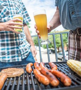 Two men grilling with beers
