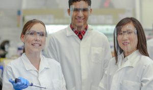 three lab professionals in a lab